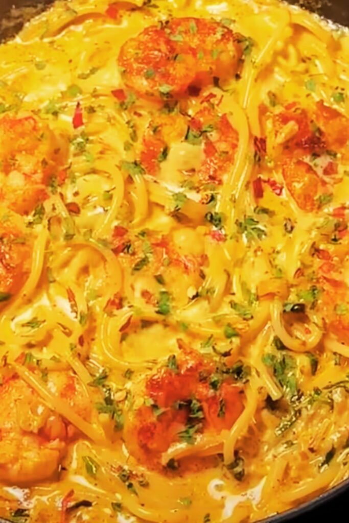 Chef cooking shrimp pasta in kitchen